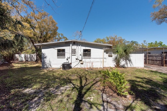 rear view of house featuring a yard and fence