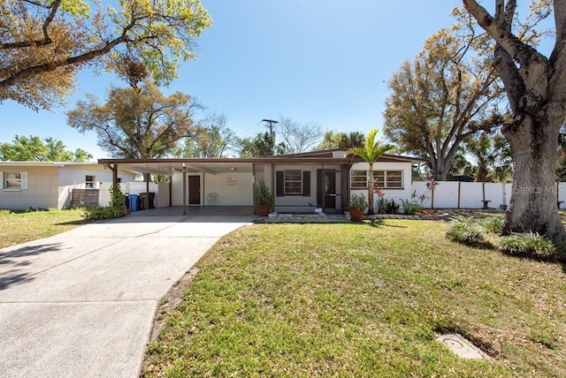 ranch-style home featuring a carport, driveway, a front lawn, and fence