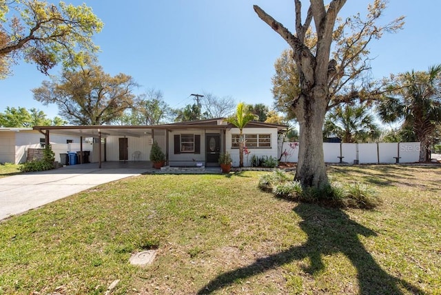 single story home with a front lawn, an attached carport, driveway, and fence