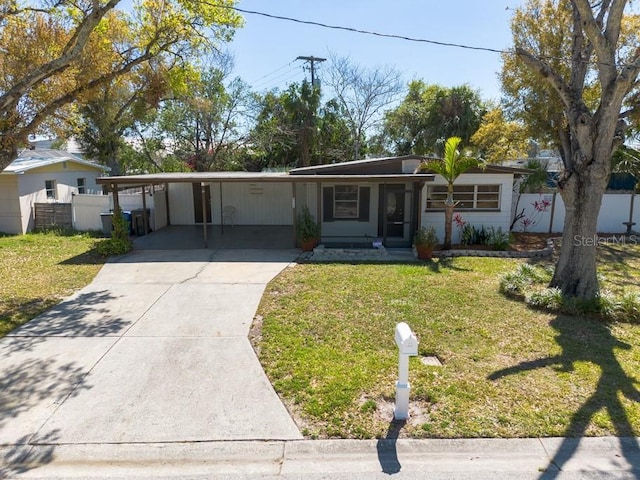 single story home featuring an attached carport, driveway, a front yard, and fence