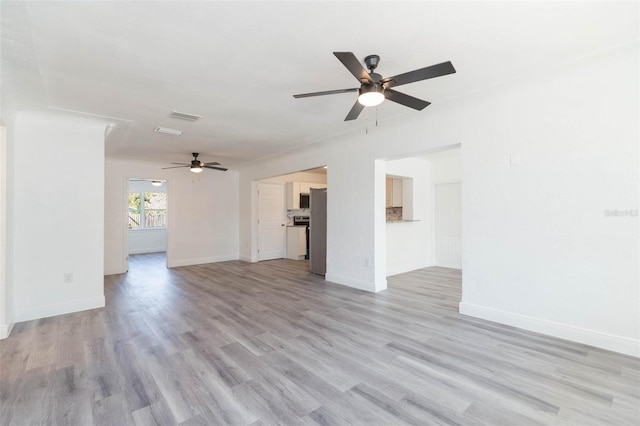 unfurnished living room with light wood-style flooring, baseboards, and ceiling fan