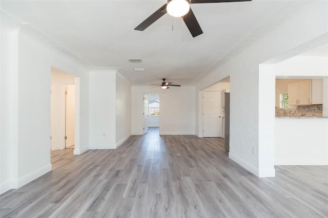 interior space with visible vents, baseboards, light wood-type flooring, and ceiling fan