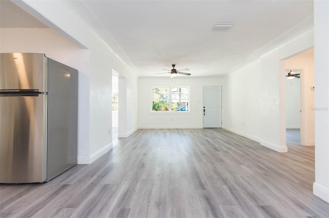 unfurnished living room featuring baseboards, wood finished floors, and ceiling fan