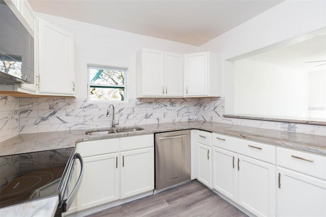 kitchen with a sink, decorative backsplash, white cabinets, and stainless steel appliances