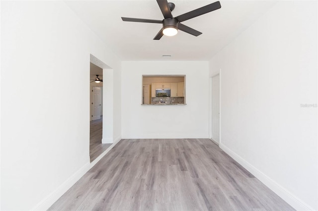 interior space featuring baseboards, light wood-type flooring, and ceiling fan