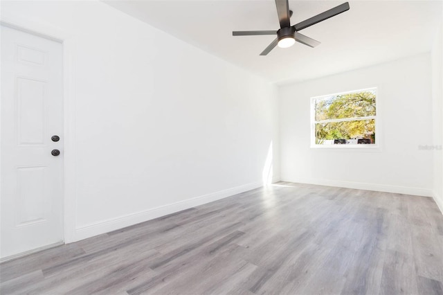 empty room with wood finished floors, baseboards, and ceiling fan