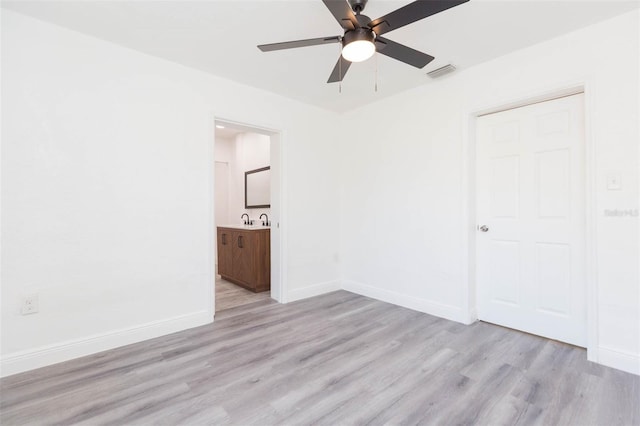 unfurnished bedroom with visible vents, baseboards, ensuite bath, and light wood finished floors