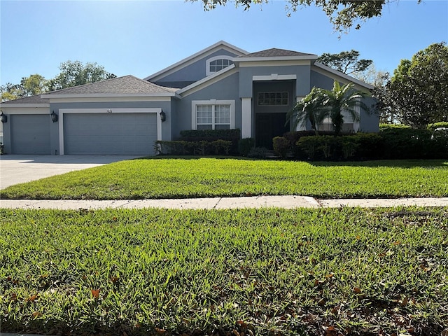 view of front of property featuring a front lawn, concrete driveway, a garage, and stucco siding