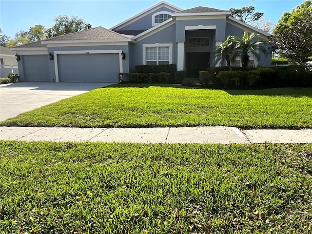 view of front of house featuring stucco siding, a front lawn, concrete driveway, an attached garage, and a shingled roof