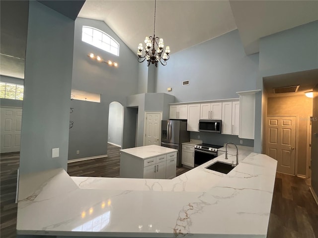 kitchen featuring light stone counters, visible vents, an inviting chandelier, a sink, and appliances with stainless steel finishes