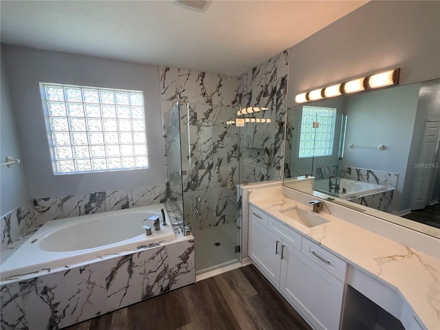 full bathroom featuring a marble finish shower, vanity, a garden tub, and wood finished floors