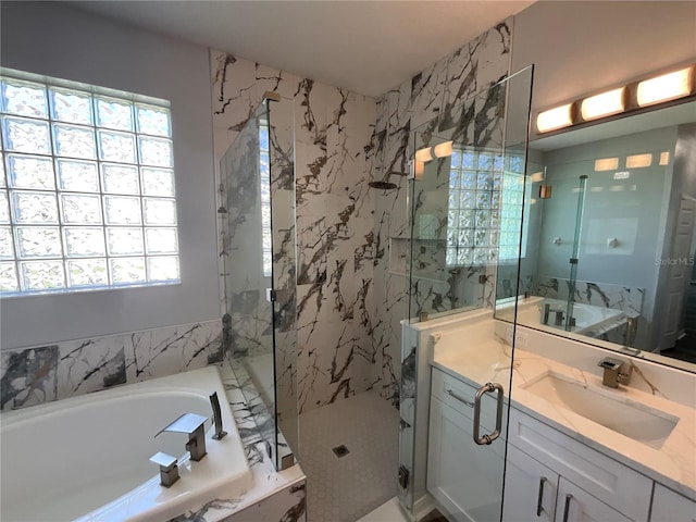 bathroom with a marble finish shower, plenty of natural light, a bath, and vanity