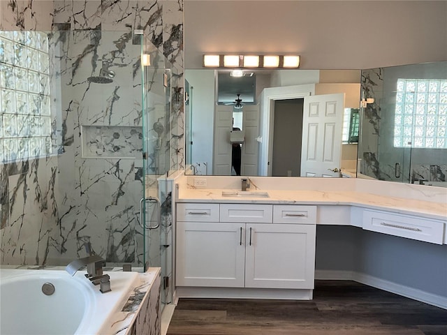 bathroom featuring a marble finish shower, ceiling fan, a garden tub, wood finished floors, and vanity