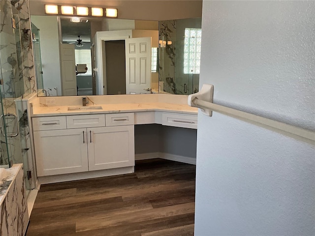 bathroom with ceiling fan, a marble finish shower, wood finished floors, and vanity