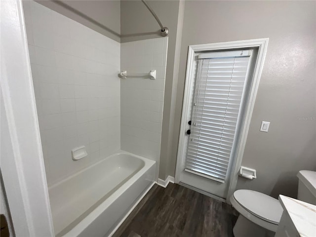 bathroom with vanity, toilet, wood finished floors, and tub / shower combination