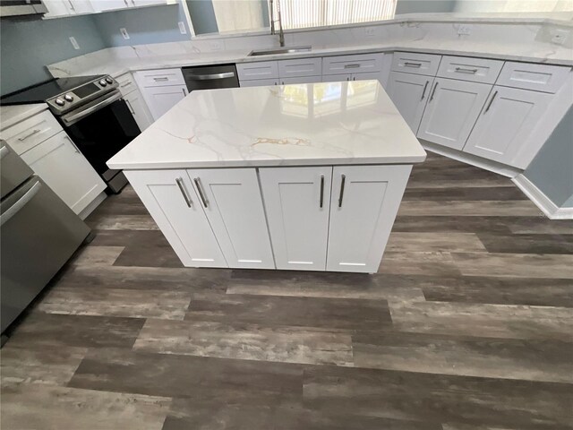 kitchen with a sink, a kitchen island, white cabinetry, stainless steel range with electric cooktop, and dark wood-style flooring