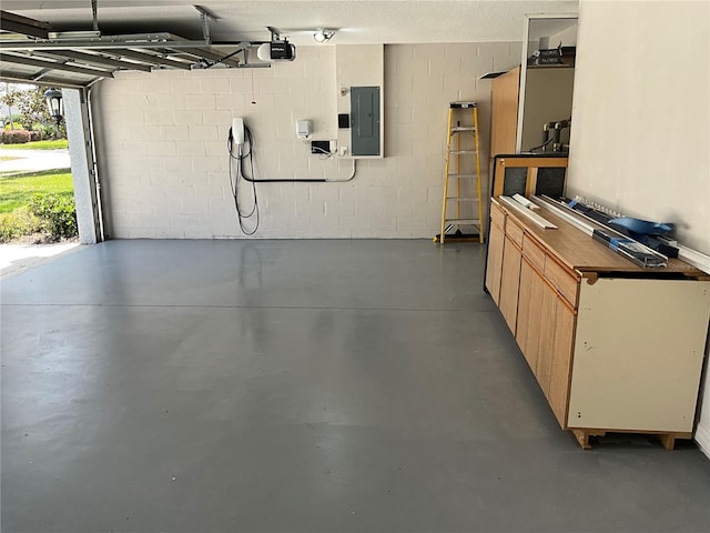 garage featuring electric panel, a garage door opener, and concrete block wall