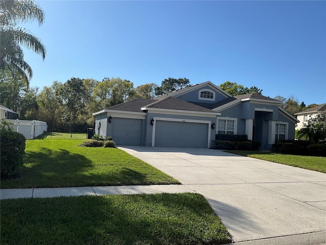 view of front of house featuring a front lawn, an attached garage, driveway, and stucco siding