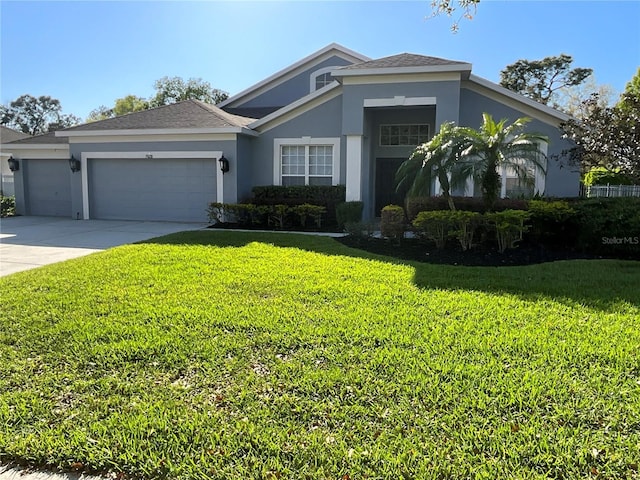 view of front of house featuring concrete driveway, a front yard, roof with shingles, stucco siding, and a garage