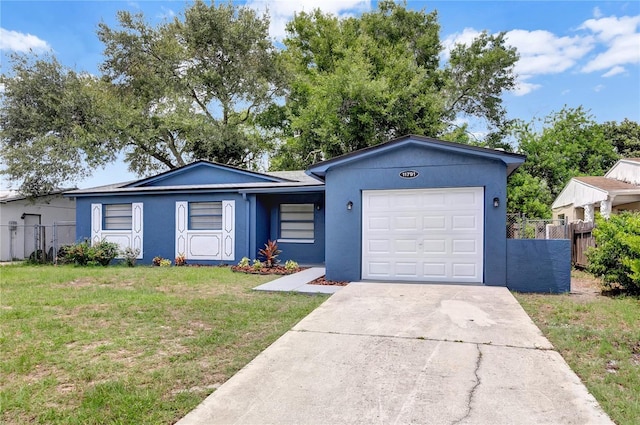 ranch-style house featuring a garage, driveway, a front lawn, and fence