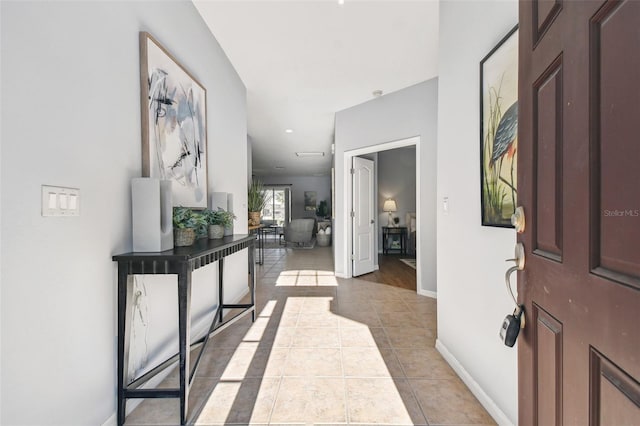 foyer entrance featuring light tile patterned floors and baseboards