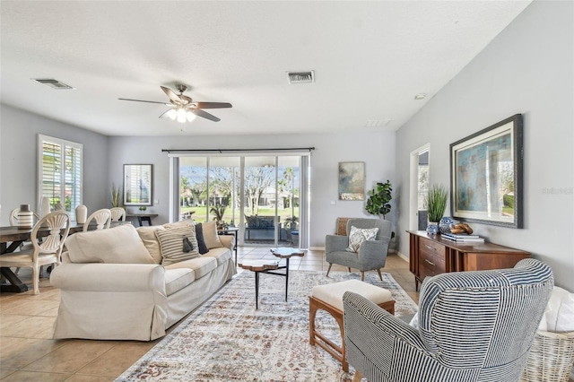 living room with light tile patterned floors, visible vents, and a ceiling fan