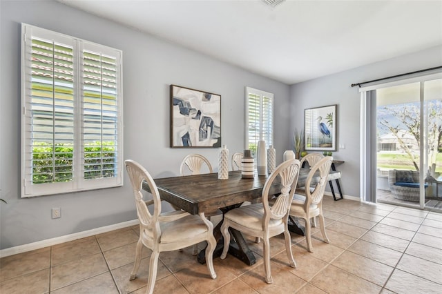 dining area with light tile patterned flooring and baseboards