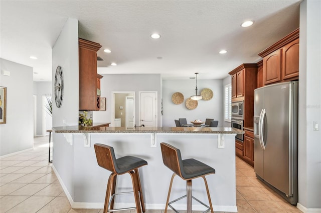 kitchen featuring a breakfast bar, light tile patterned floors, recessed lighting, appliances with stainless steel finishes, and a peninsula