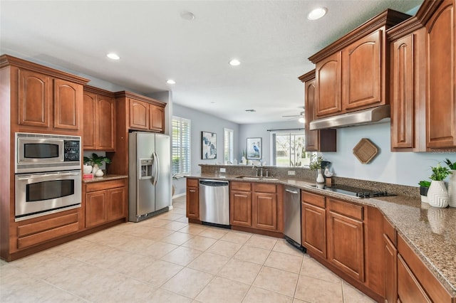 kitchen featuring a peninsula, ceiling fan, a sink, under cabinet range hood, and appliances with stainless steel finishes