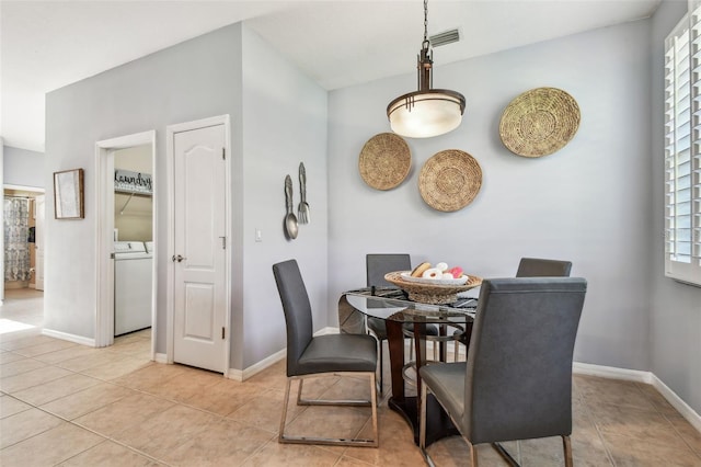 dining space with baseboards, light tile patterned flooring, and washer and clothes dryer