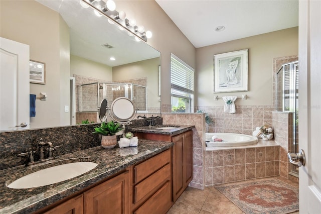 bathroom with tile patterned flooring, a shower stall, a bath, and a sink