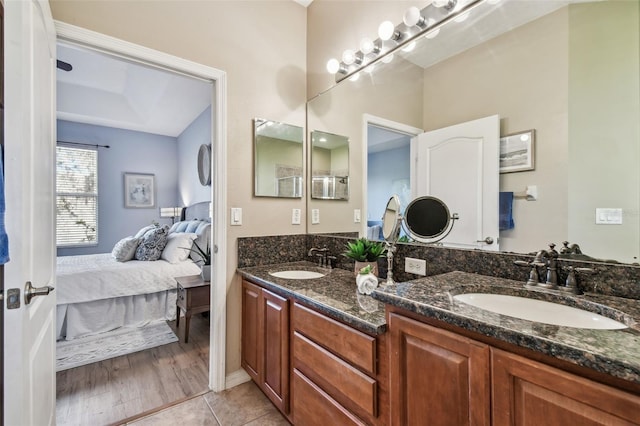 bathroom with a sink, connected bathroom, double vanity, and tile patterned floors