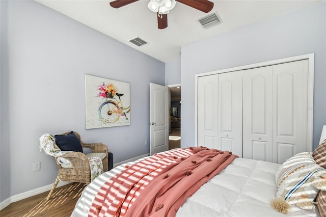 bedroom featuring wood finished floors, visible vents, a closet, and baseboards