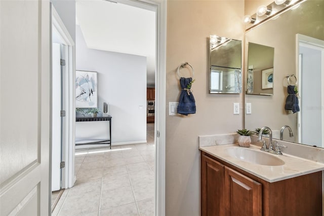 bathroom featuring tile patterned floors, baseboards, and vanity