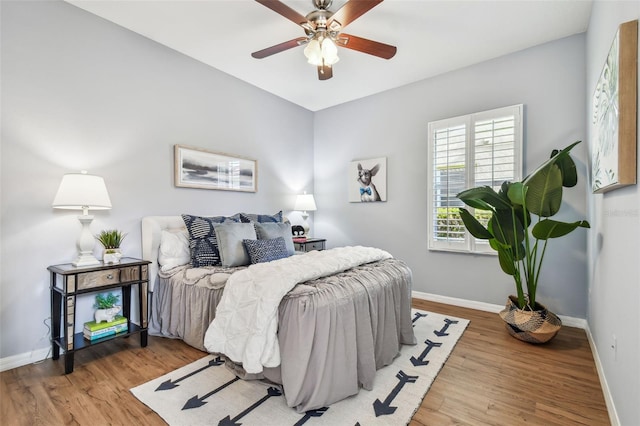 bedroom with ceiling fan, baseboards, and wood finished floors