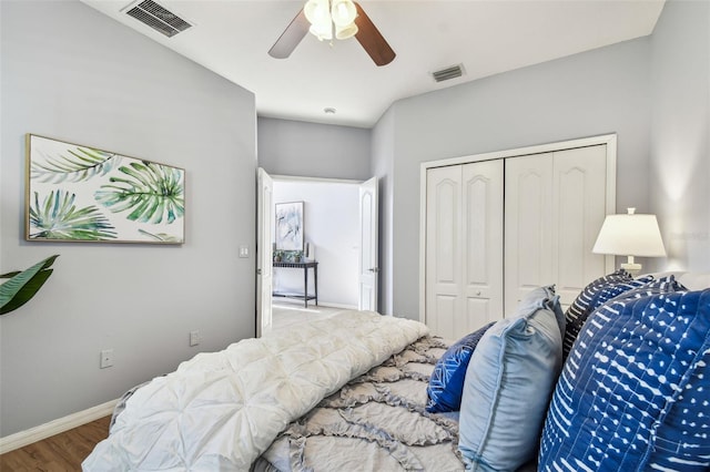 bedroom featuring visible vents, baseboards, a closet, and wood finished floors