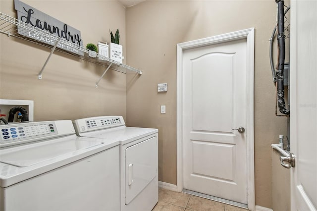 laundry room featuring light tile patterned floors, laundry area, baseboards, and separate washer and dryer