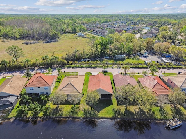 aerial view with a residential view, a view of trees, and a water view