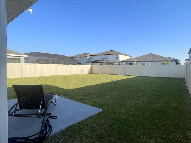 view of yard featuring a patio area, a residential view, and a fenced backyard