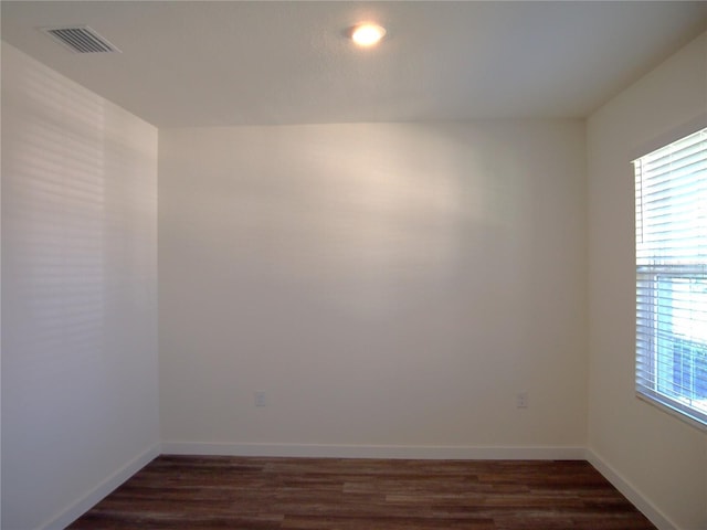31888 Treasure Dock Isle, Wesley Chapel, FL 33545 - empty room with visible vents, a healthy amount of sunlight, and dark wood-style flooring