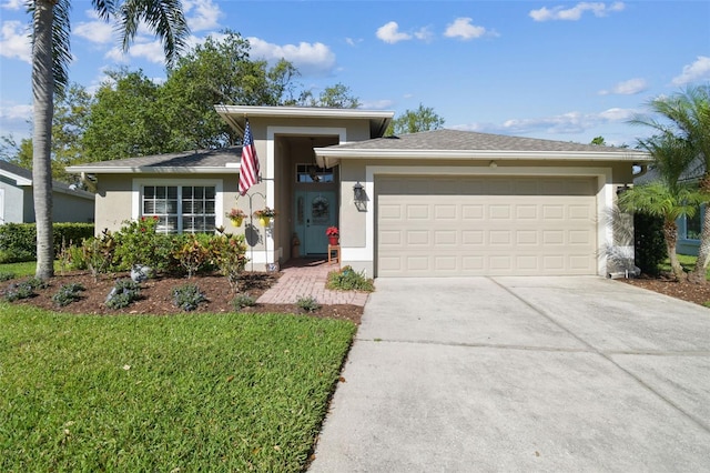 view of front of property with stucco siding, a front lawn, an attached garage, and driveway