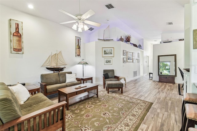 living room with visible vents, light wood-style floors, and a ceiling fan