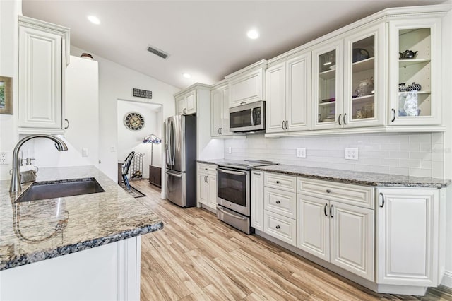 kitchen with visible vents, lofted ceiling, light wood-style flooring, appliances with stainless steel finishes, and a sink