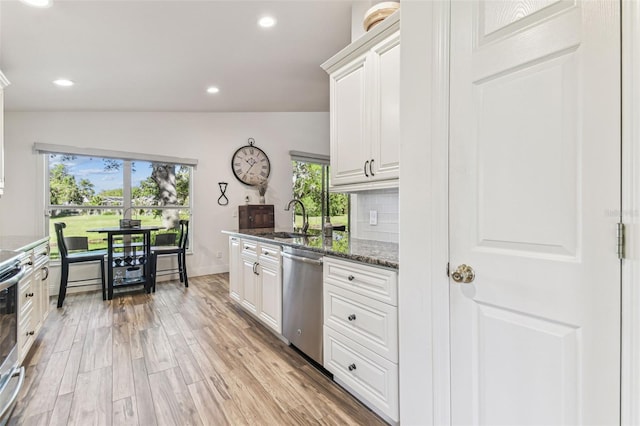 kitchen featuring a sink, decorative backsplash, white cabinets, light wood-style floors, and appliances with stainless steel finishes