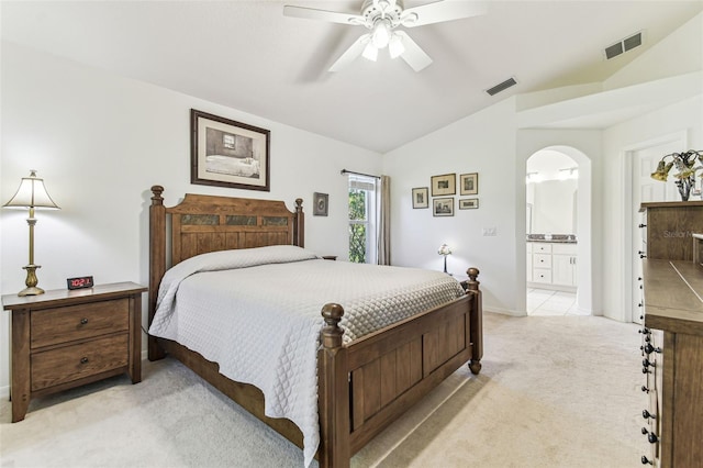 bedroom with arched walkways, visible vents, light colored carpet, and vaulted ceiling