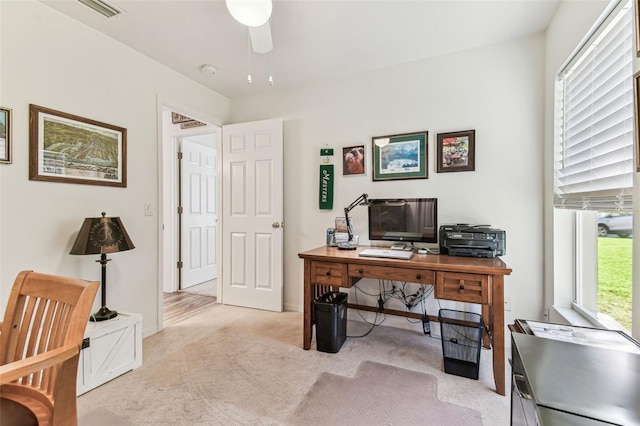 carpeted office space featuring visible vents and ceiling fan