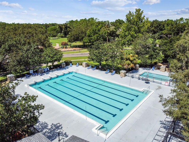 community pool with a patio and fence