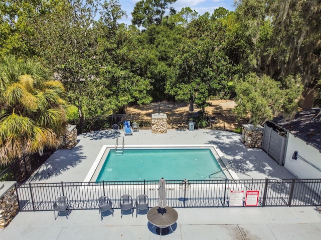 community pool with a patio area and fence