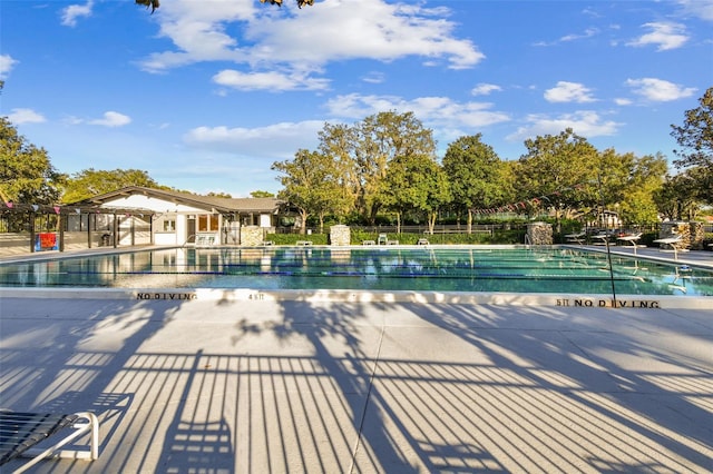 community pool featuring a patio and fence