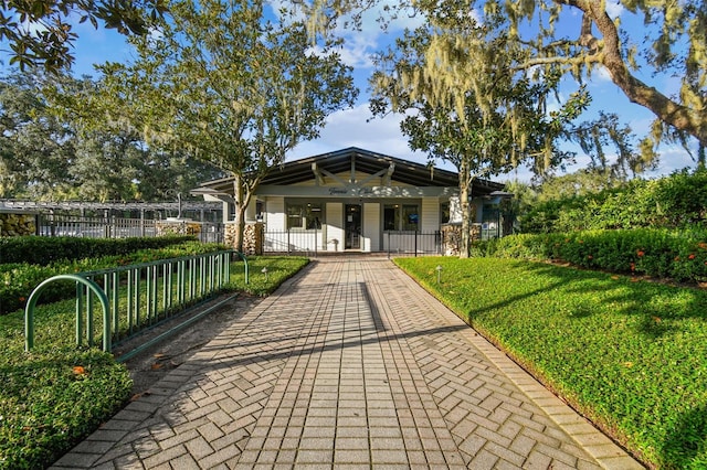 view of community featuring a fenced front yard and a lawn